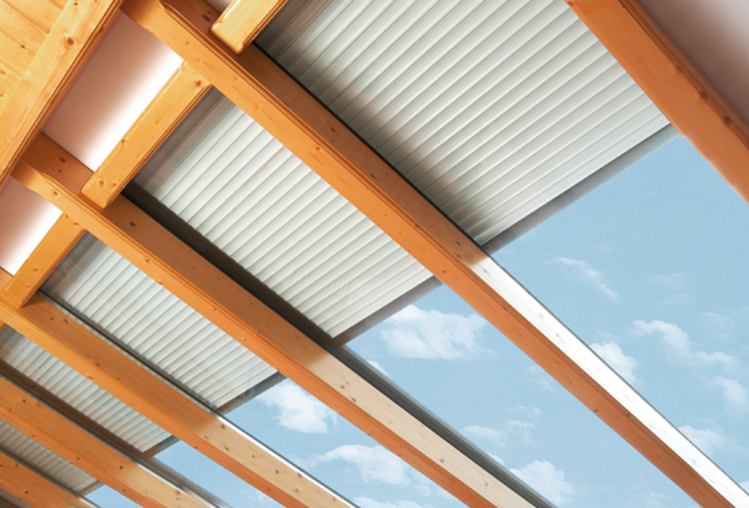Zur Hälfte herabgelassene Dachfenster-Rollläden an einer Glasdachfront mit Holzbalken Unterkonstruktion Zur Hälfte herabgelassene Dachfenster-Rollläden an einer Glasdachfront mit Holzbalken Unterkonstruktion