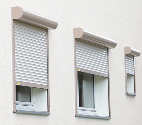 Referenz Rollläden: Detailansicht Fensterfront mit nachträglich angebauten alufarbenden Rollläden, teilweise heruntergefahren.